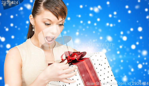 Image of smiling woman in red dress with gift box