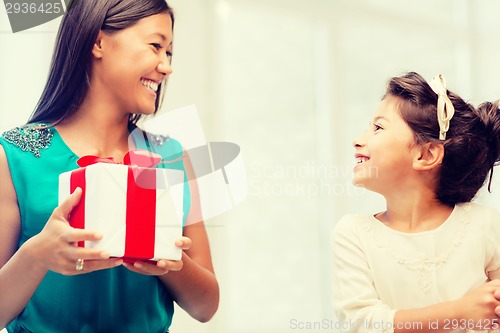 Image of happy mother and child girl with gift box