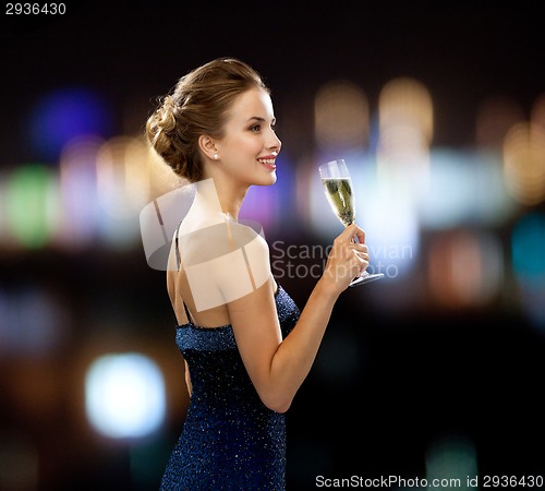 Image of smiling woman holding glass of sparkling wine