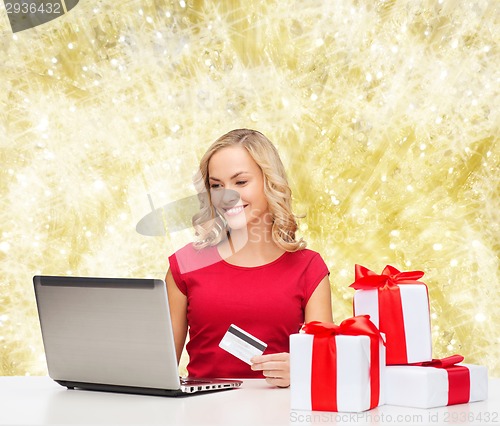Image of smiling woman with credit card and laptop