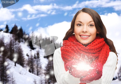 Image of smiling woman in winter clothes with snowflake