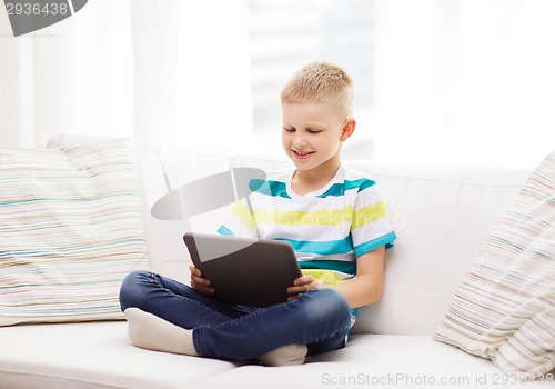 Image of smiling boy with tablet computer at home