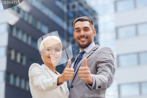 Image of smiling businessmen showing thumbs up