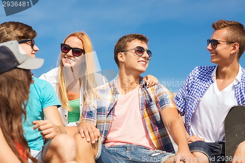 Image of group of smiling friends sitting on city street