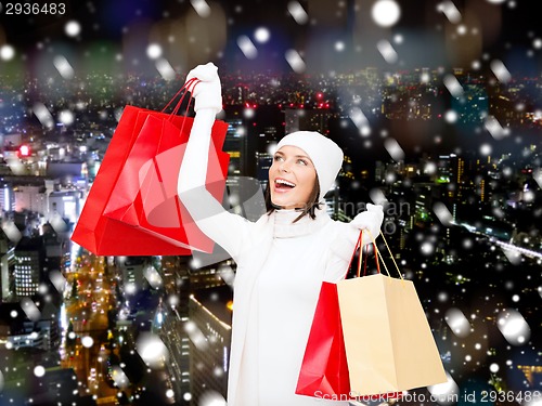 Image of smiling young woman with red shopping bags