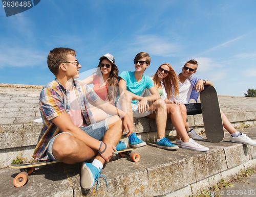 Image of group of smiling friends sitting on city street