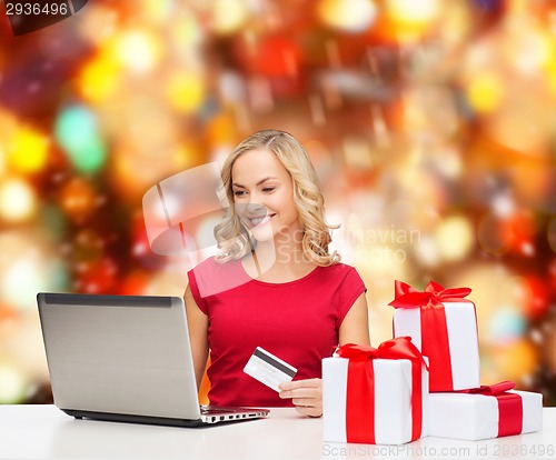 Image of smiling woman with credit card and laptop