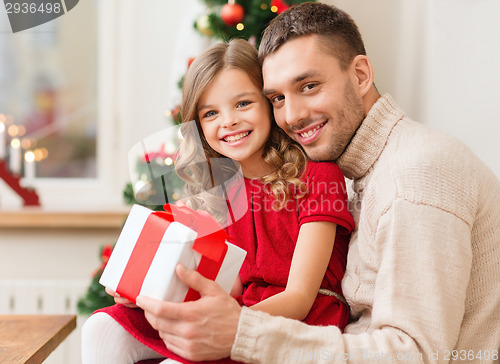 Image of smiling father and daughter holding gift box