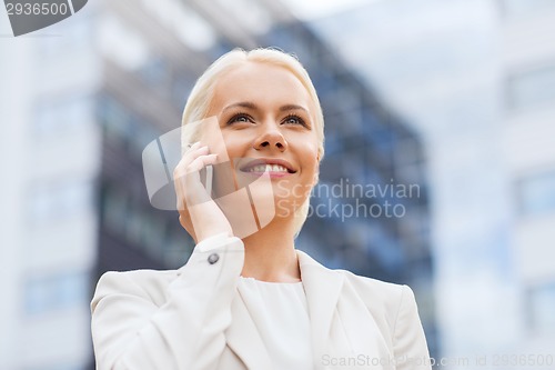 Image of smiling businesswoman with smartphone outdoors