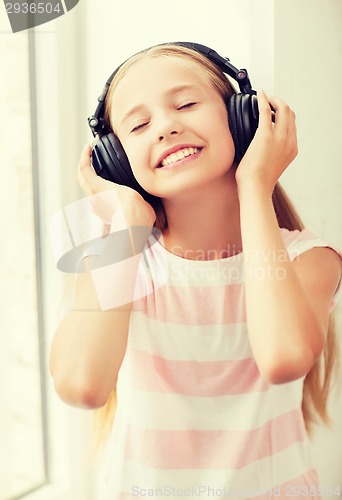 Image of little girl with headphones at home