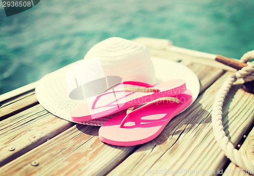 Image of close up of hat and slippers at seaside