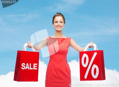 Image of young woman in red dress with shopping bags
