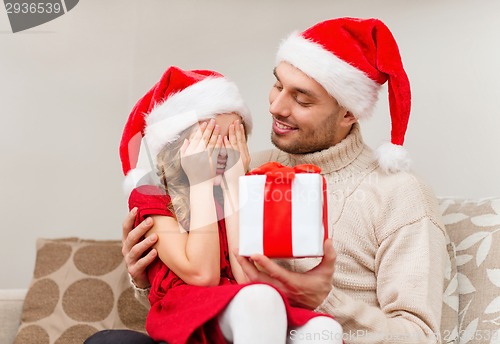 Image of smiling daughter waiting for a present from father