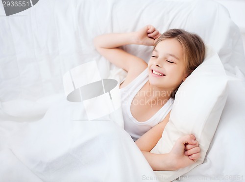 Image of smiling girl child waking up in bed at home