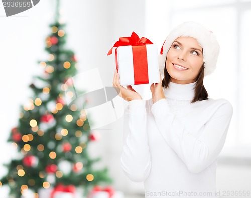 Image of smiling woman in santa helper hat with gift box