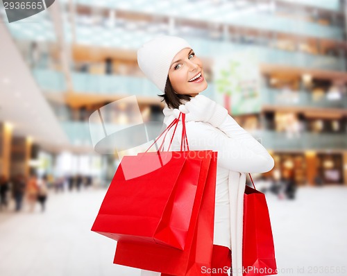 Image of smiling young woman with red shopping bags