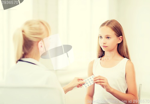 Image of doctor giving tablets to child in hospital