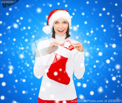 Image of woman in santa hat with gift box and stocking