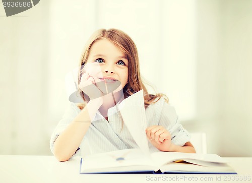 Image of little student girl studying at school