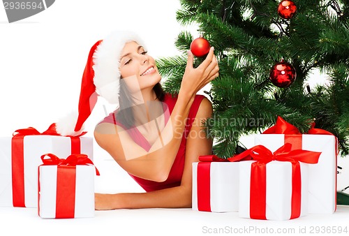 Image of smiling woman in santa helper hat with gift boxes