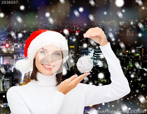 Image of woman in santa helper hat with christmas ball