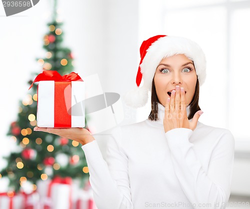 Image of smiling woman in santa helper hat with gift box