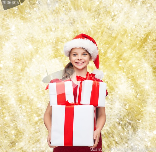 Image of smiling little girl in santa helper hat with gifts