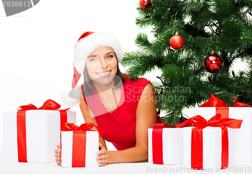 Image of smiling woman in santa helper hat with gift boxes