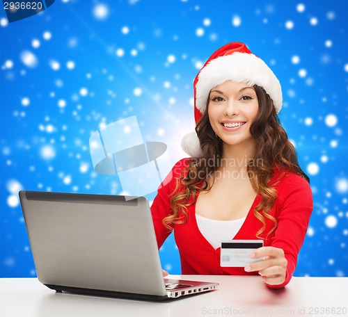 Image of smiling woman with credit card and laptop