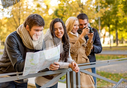 Image of group of friends with map and camera outdoors