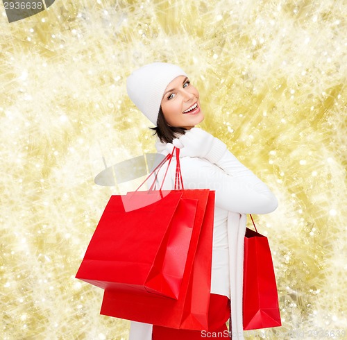 Image of smiling young woman with red shopping bags