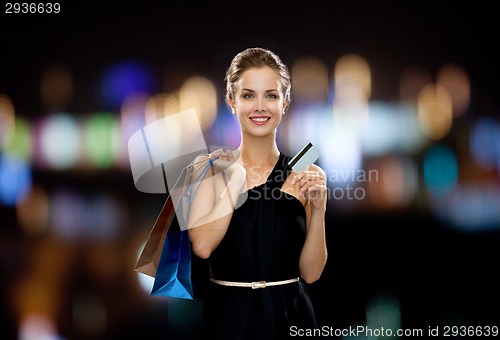 Image of smiling woman with shopping bags and credit card