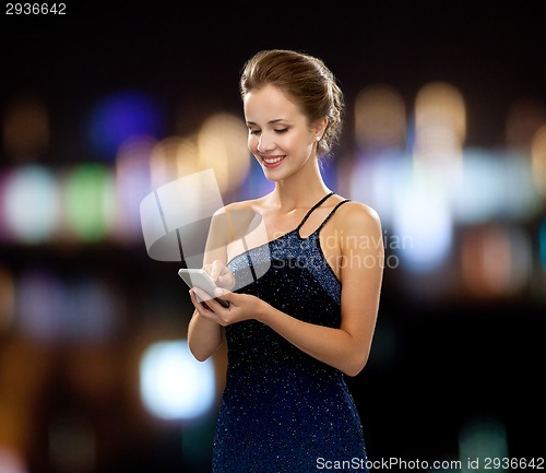 Image of smiling woman in evening dress with smartphone
