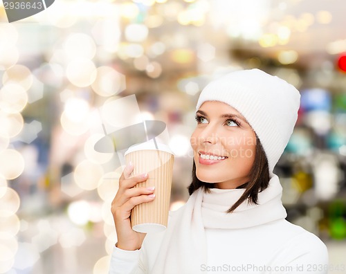 Image of smiling young woman in winter clothes with cup