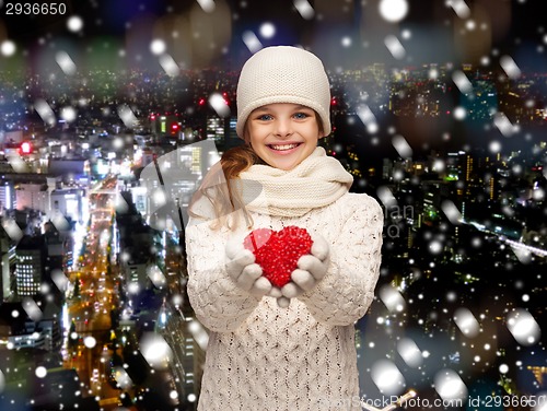 Image of dreaming girl in winter clothes with red heart