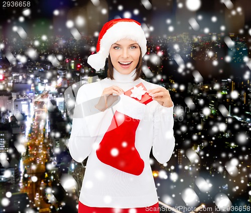 Image of woman in santa hat with gift box and stocking