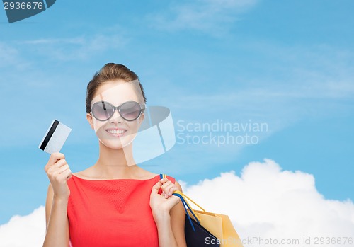 Image of smiling woman with shopping bags and plastic card