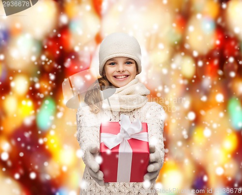Image of girl in hat, muffler and gloves with gift box