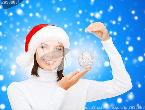 Image of woman in santa helper hat with christmas ball