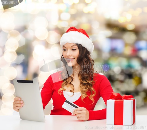 Image of smiling woman with credit card and tablet pc