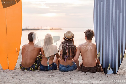 Image of group of friends in sunglasses with surfs on beach