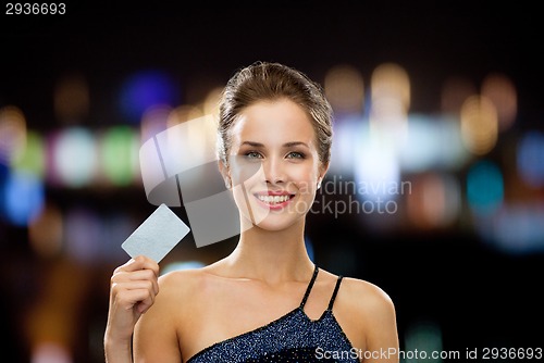Image of smiling woman in evening dress holding credit card