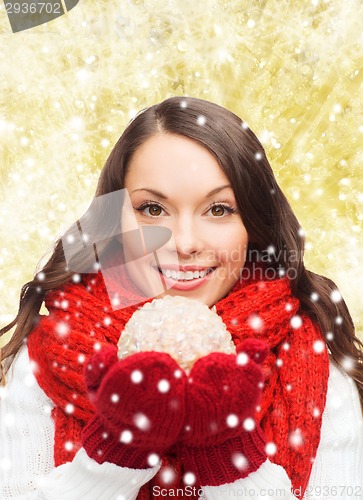 Image of smiling woman in winter clothes with snowball