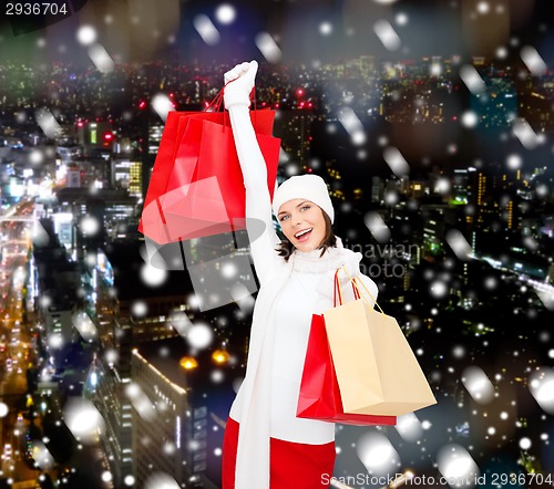 Image of smiling young woman with red shopping bags