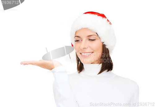 Image of woman in santa helper hat with something on palm