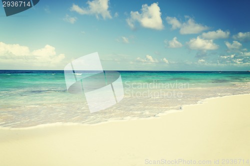 Image of blue sea or ocean, white sand and sky with clouds