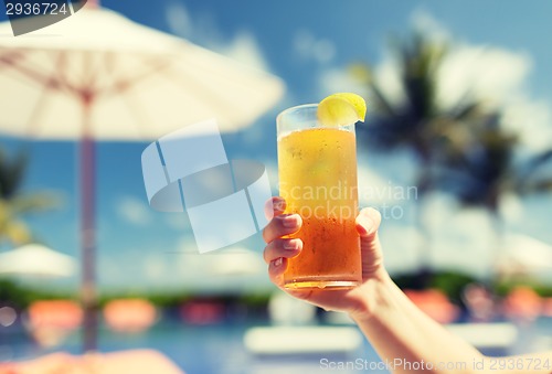 Image of close-up of hand holding glass with cocktail