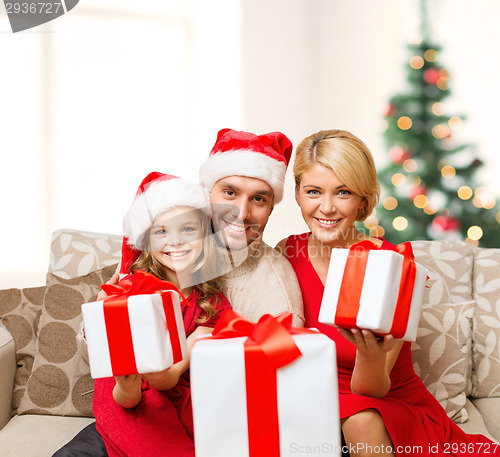 Image of smiling family giving many gift boxes