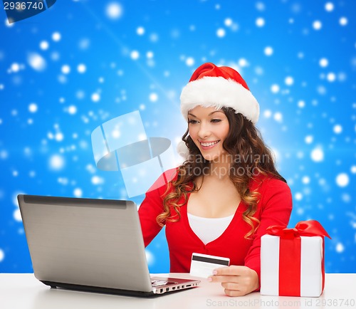 Image of smiling woman with credit card and laptop