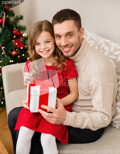 Image of smiling father and daughter holding gift box